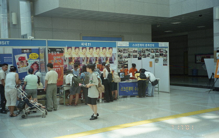 '스크린쿼터 문화연대'라 적힌 수호천사단 모집 부스에 사람들이 모여 서명을 하는 모습
